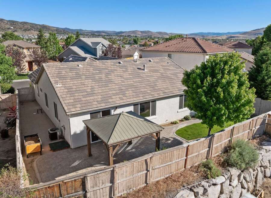Enjoy outdoor living in this spacious backyard featuring a covered patio perfect for entertaining and a lush green lawn.