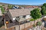 Enjoy outdoor living in this spacious backyard featuring a covered patio perfect for entertaining and a lush green lawn.