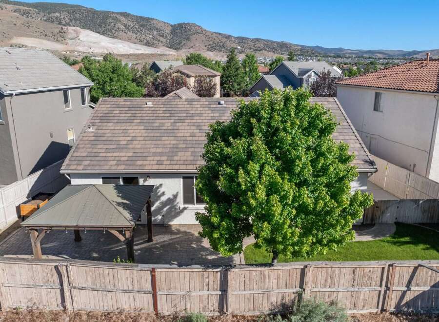 Enjoy outdoor living in this backyard featuring a covered patio with string lights, perfect for entertaining.