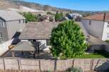 Enjoy outdoor living in this backyard featuring a covered patio with string lights, perfect for entertaining.