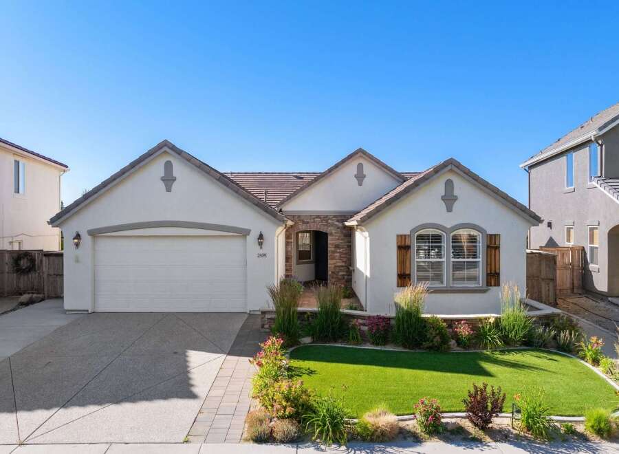 Discover this charming single-story home featuring a welcoming facade with stone accents and a well-maintained lawn.