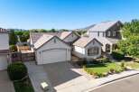 Discover this charming single-family home featuring a spacious two-car garage and a beautifully landscaped front yard with vibrant flowers and lush green grass.