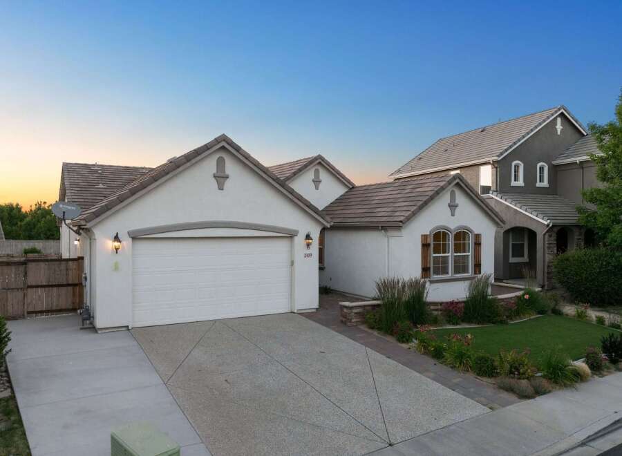 Discover this charming home featuring a spacious driveway leading to a two-car garage.