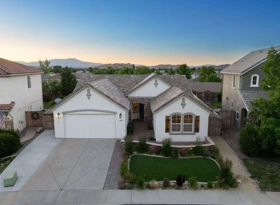 Discover this charming single-family home featuring a welcoming facade with a well-maintained lawn and mature landscaping.
