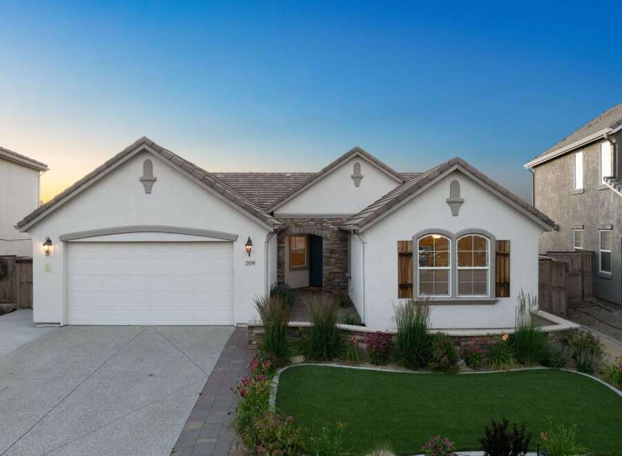 Discover this charming single-story home featuring a welcoming facade with stone accents and a well-maintained lawn.