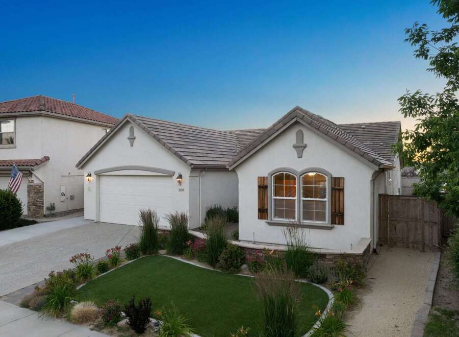 Charming single-story home featuring a welcoming facade with decorative shutters and a well-maintained lawn.