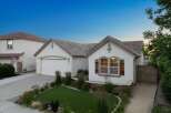 Charming single-story home featuring a welcoming facade with decorative shutters and a well-maintained lawn.