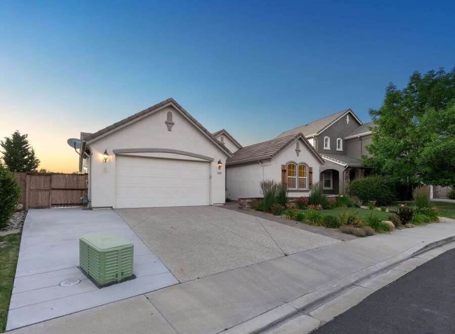 This charming home features a spacious driveway leading to an attached garage, perfect for vehicle storage and easy access.
