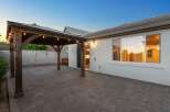 Enjoy outdoor living under this charming wooden pergola, complete with string lights for evening ambiance.