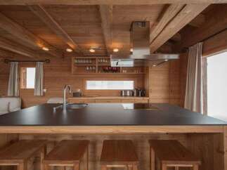 Experience rustic charm in this beautifully appointed wooden kitchen, featuring a spacious island with a dark countertop perfect for meal preparation and casual dining.