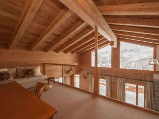 Experience luxury mountain living in this stunning chalet featuring a spacious loft area with breathtaking panoramic views of snow-capped peaks.