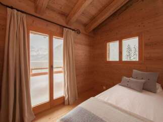 Experience cozy mountain living in this charming wooden cabin bedroom.