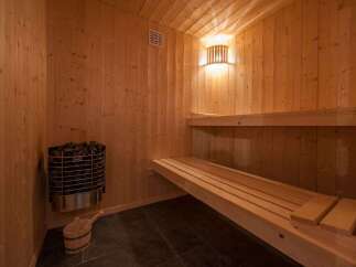 Experience ultimate relaxation in this authentic Finnish sauna, featuring warm wooden interiors and a powerful heater.