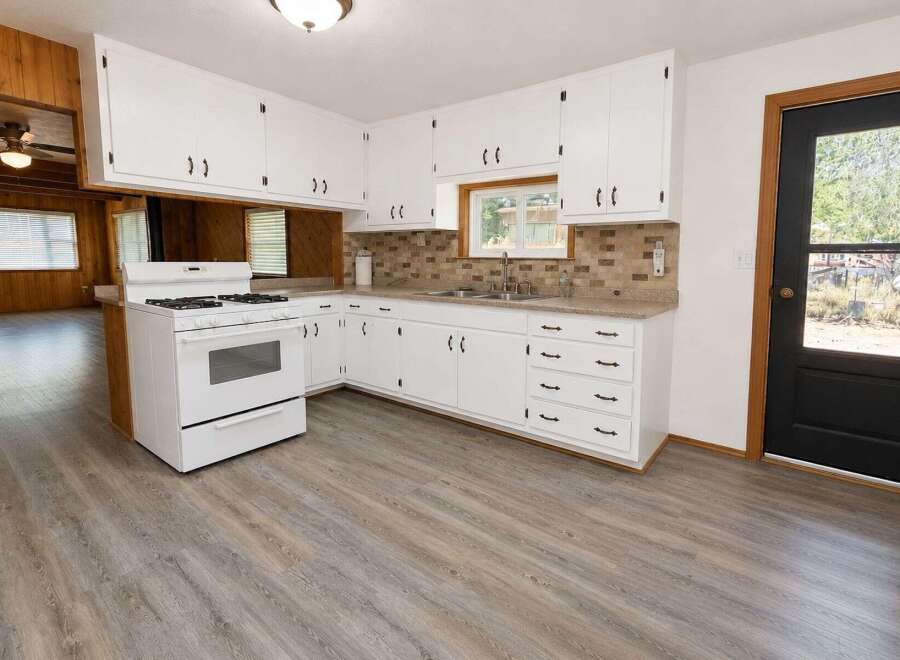 Step into this charming kitchen featuring crisp white cabinetry and a classic white gas range, perfect for home chefs.