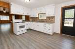Step into this charming kitchen featuring crisp white cabinetry and a classic white gas range, perfect for home chefs.