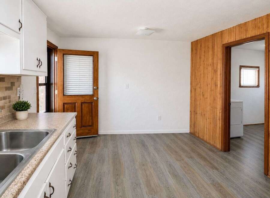 Discover a charming kitchen space featuring a double sink and ample cabinet storage, perfect for everyday meal preparation.