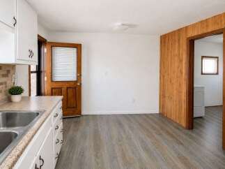 Discover a charming kitchen space featuring a double sink and ample cabinet storage, perfect for everyday meal preparation.