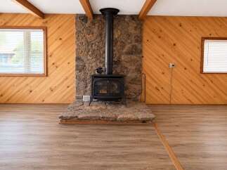 Cozy up by the rustic stone fireplace, a stunning focal point in this inviting living space.