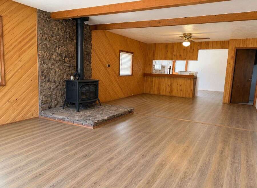 Cozy living room featuring a striking stone fireplace with a black wood-burning stove, perfect for chilly evenings.