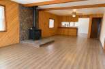 Cozy living room featuring a striking stone fireplace with a black wood-burning stove, perfect for chilly evenings.