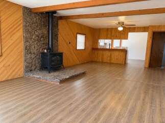 Cozy living room featuring a striking stone fireplace with a black wood-burning stove, perfect for chilly evenings.