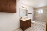 This updated bathroom features a spacious vanity with ample storage and a cream-colored countertop.