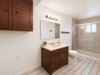 This updated bathroom features a spacious vanity with ample storage and a cream-colored countertop.