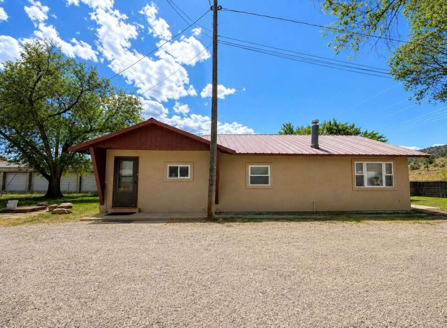 Discover this charming single-story home featuring a durable metal roof and a welcoming tan stucco exterior.