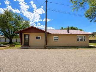 Discover this charming single-story home featuring a durable metal roof and a welcoming tan stucco exterior.