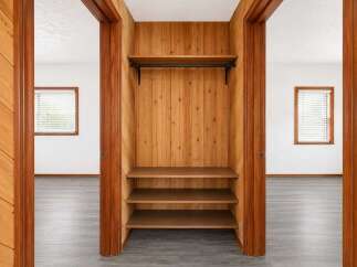 Discover ample storage solutions in this charming home, featuring a built-in closet with a hanging rod and three spacious shelves.