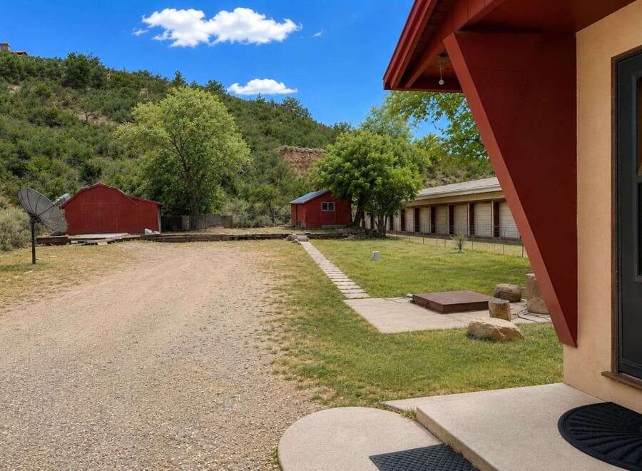 Discover this unique property featuring multiple outbuildings, including two charming red barns and a long, motel-style structure with individual units.