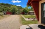 Discover this unique property featuring multiple outbuildings, including two charming red barns and a long, motel-style structure with individual units.