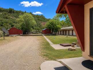 Discover this unique property featuring multiple outbuildings, including two charming red barns and a long, motel-style structure with individual units.