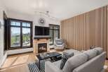 Experience modern mountain living in this stunning living room, featuring a cozy stone fireplace and a sleek entertainment center.