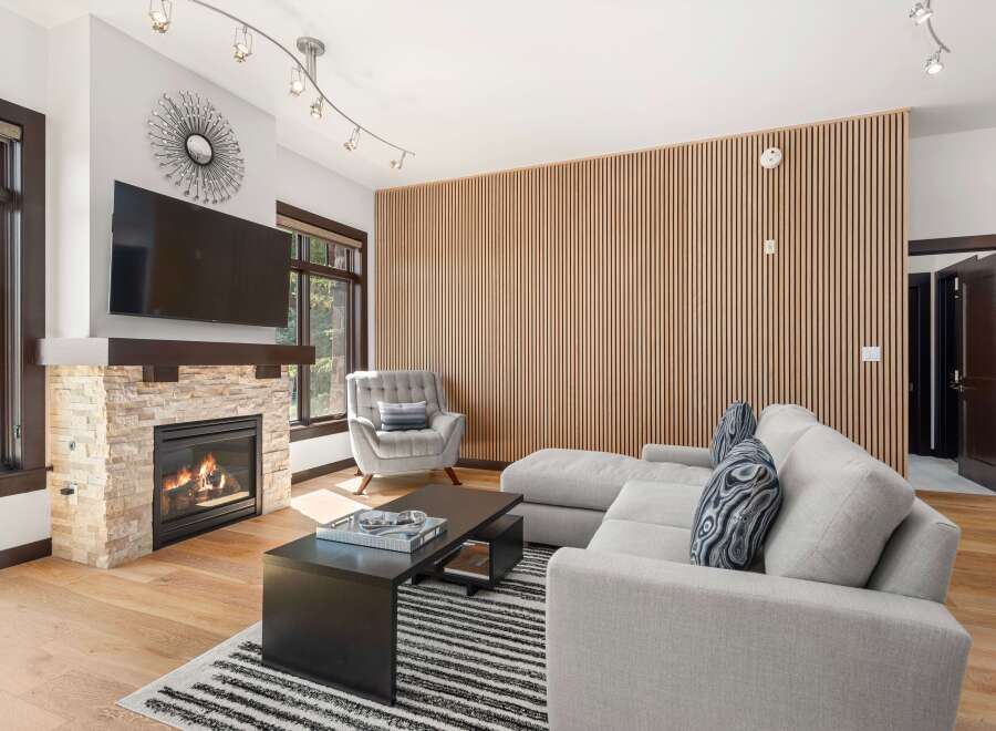 Experience modern living in this stunning living room, featuring a cozy stone fireplace and a sleek entertainment center.