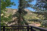 Enjoy breathtaking mountain views from this property's private balcony, framed by lush evergreen trees.