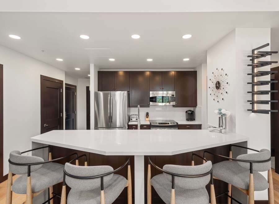 Experience modern living in this stunning kitchen featuring a sleek white quartz island perfect for entertaining.