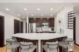 Experience modern living in this stunning kitchen featuring a sleek white quartz island perfect for entertaining.