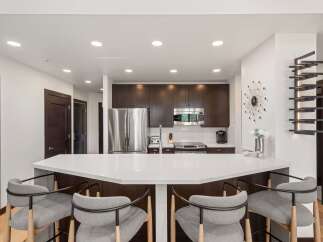 Experience modern living in this stunning kitchen featuring a sleek white quartz island perfect for entertaining.