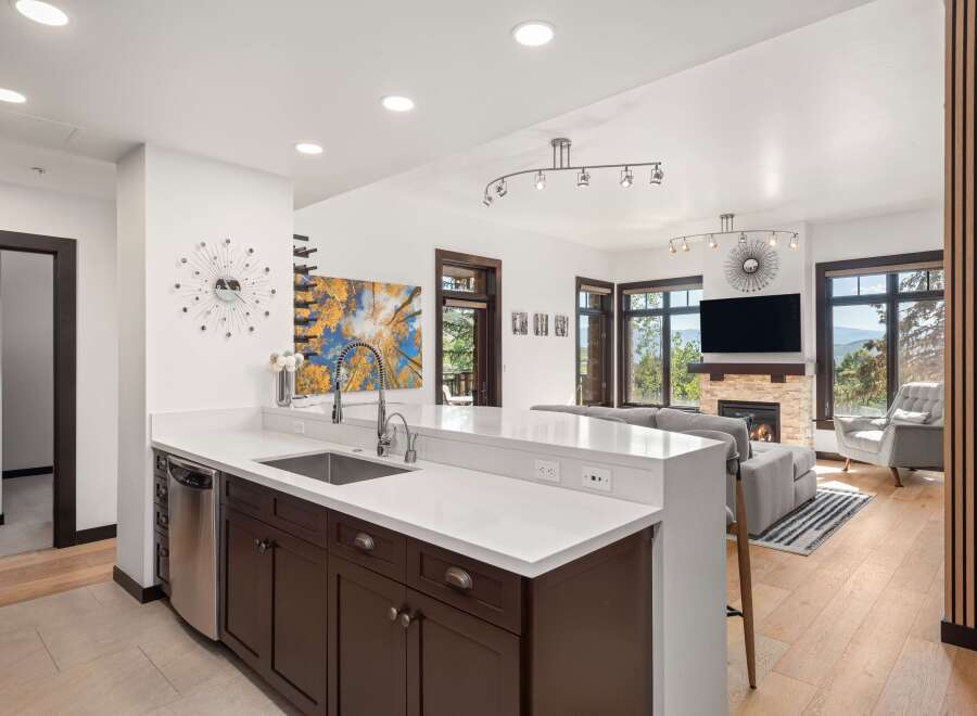 Experience modern living in this stunning open-concept home, featuring a sleek kitchen with a large island and stainless steel appliances.