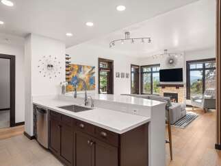 Experience modern living in this stunning open-concept home, featuring a sleek kitchen with a large island and stainless steel appliances.