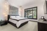 Experience luxury in this master bedroom featuring a king-sized bed with crisp white linens and elegant dark trim.