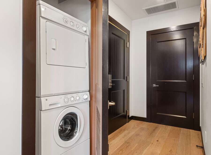 This hallway features a stacked GE washer and dryer for convenient laundry access.