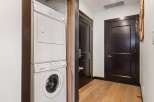 This hallway features a stacked GE washer and dryer for convenient laundry access.