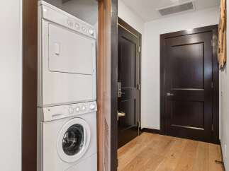 This hallway features a stacked GE washer and dryer for convenient laundry access.