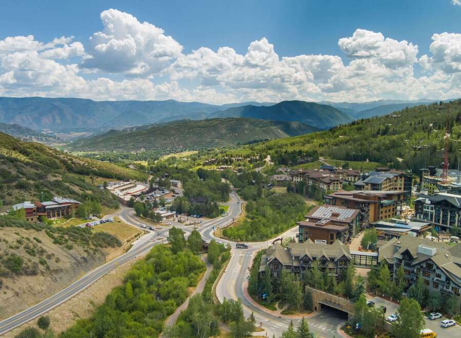 Discover luxury mountain living in this stunning aerial view of a resort community nestled amidst rolling hills and majestic peaks.