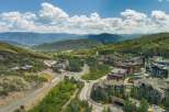 Discover luxury mountain living in this stunning aerial view of a resort community nestled amidst rolling hills and majestic peaks.