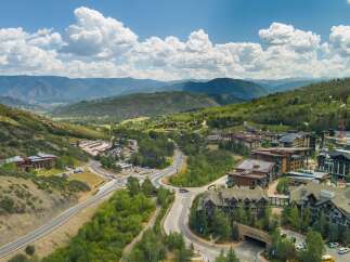 Discover luxury mountain living in this stunning aerial view of a resort community nestled amidst rolling hills and majestic peaks.