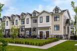 Discover modern townhome living in this stunning property featuring a multi-tone exterior with stone accents and sleek black window frames.