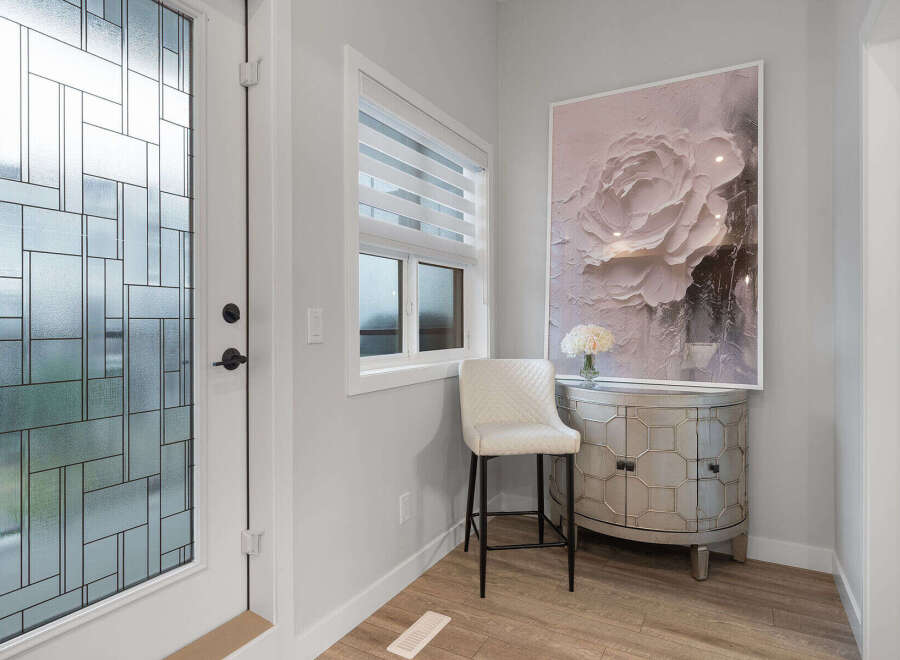 Step into a welcoming entryway featuring a decorative glass door and a stylish bar stool.